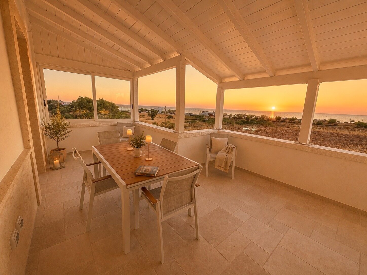 The private terrace at sunset, table laid, the Adriatic beyond